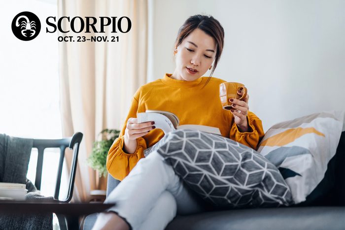 woman elaxing with tea and reading on couch