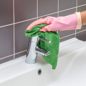 In the bathroom, ceramic sink, tiles and water tap washing.