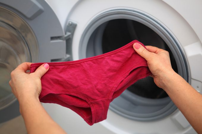 red underwear in hands for laundry