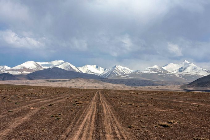 Road leading towards snow mountains