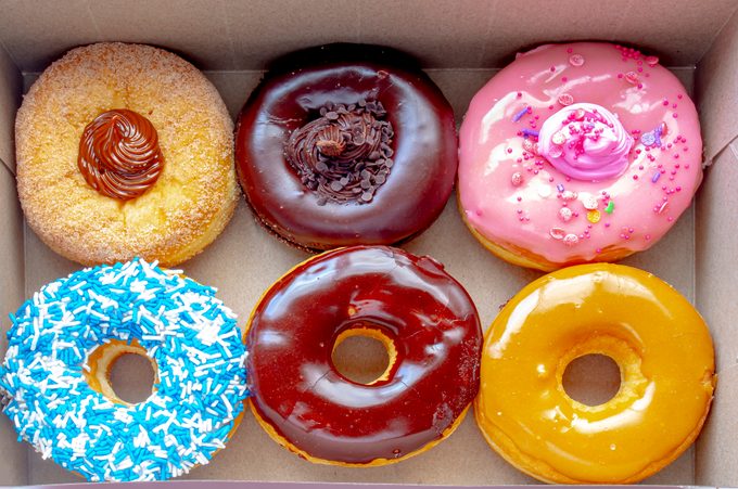 Top view Inside of a Tim Hortons six donuts box, with a: Dulce de Leche, Chocolate Truffle, Strawberry, Vanilla Dip, Chocolate, Maple Dip Donut.