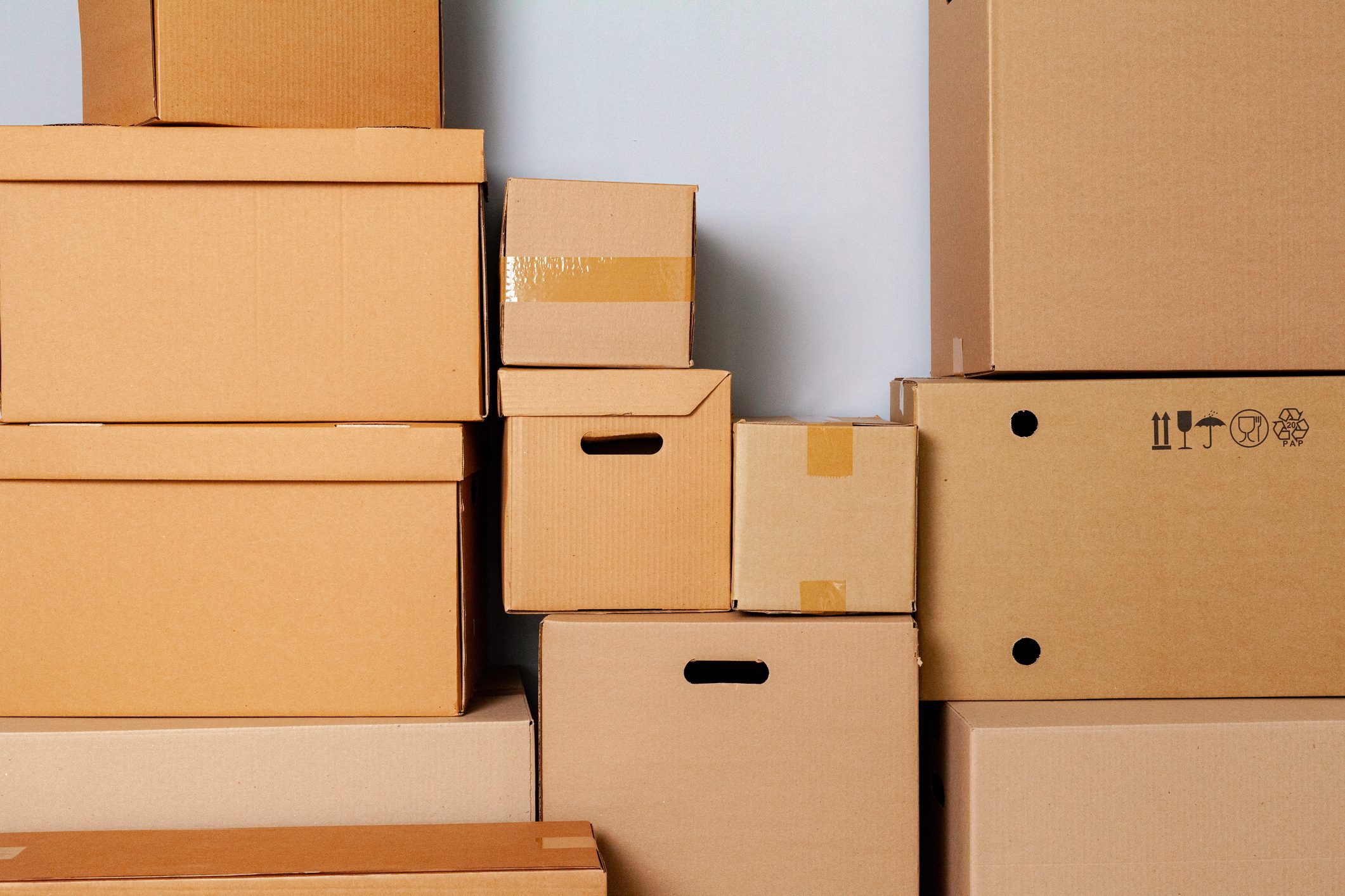 Cardboard boxes for moving on the floor against grey wall
