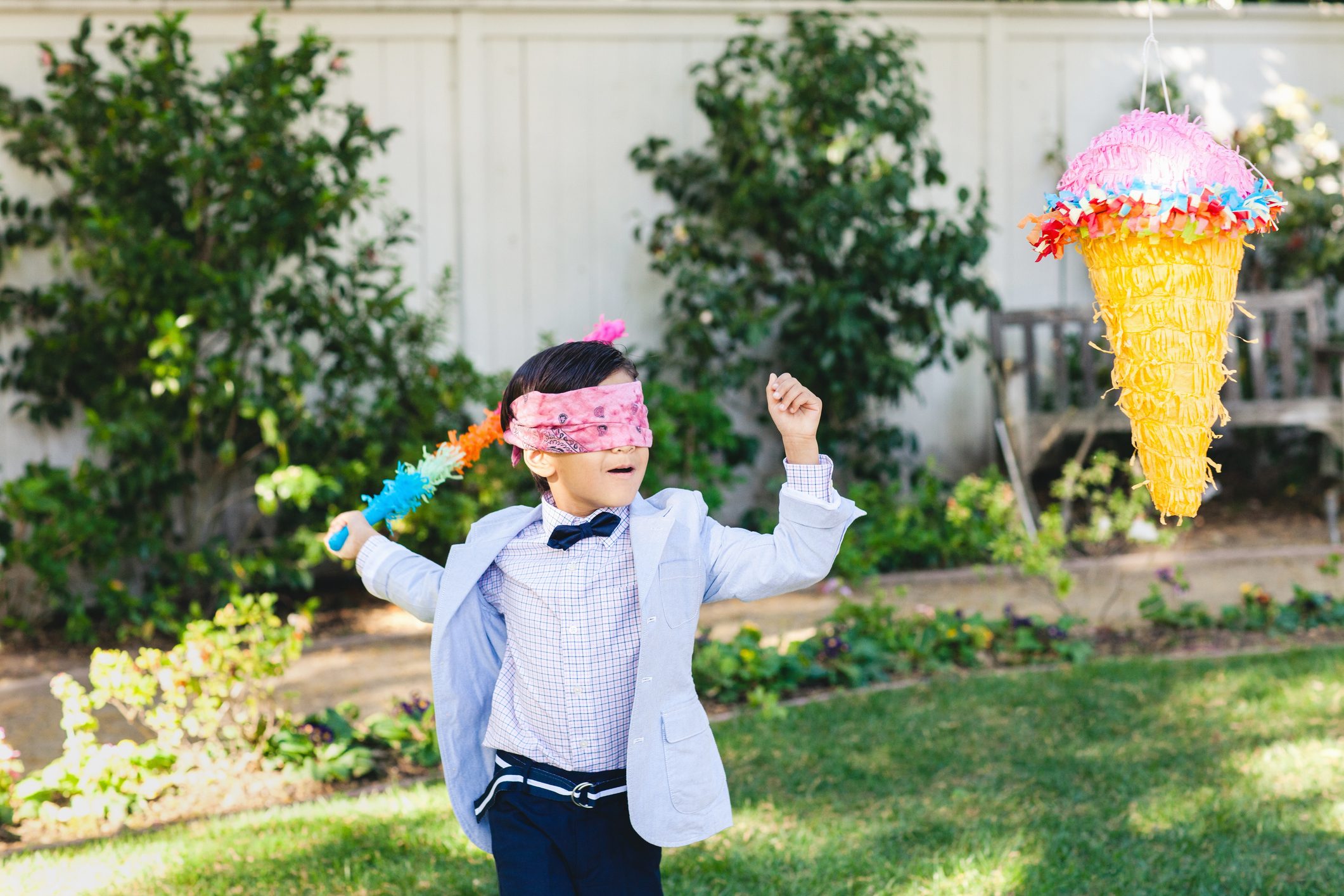 Boy at birthday party hitting piñata