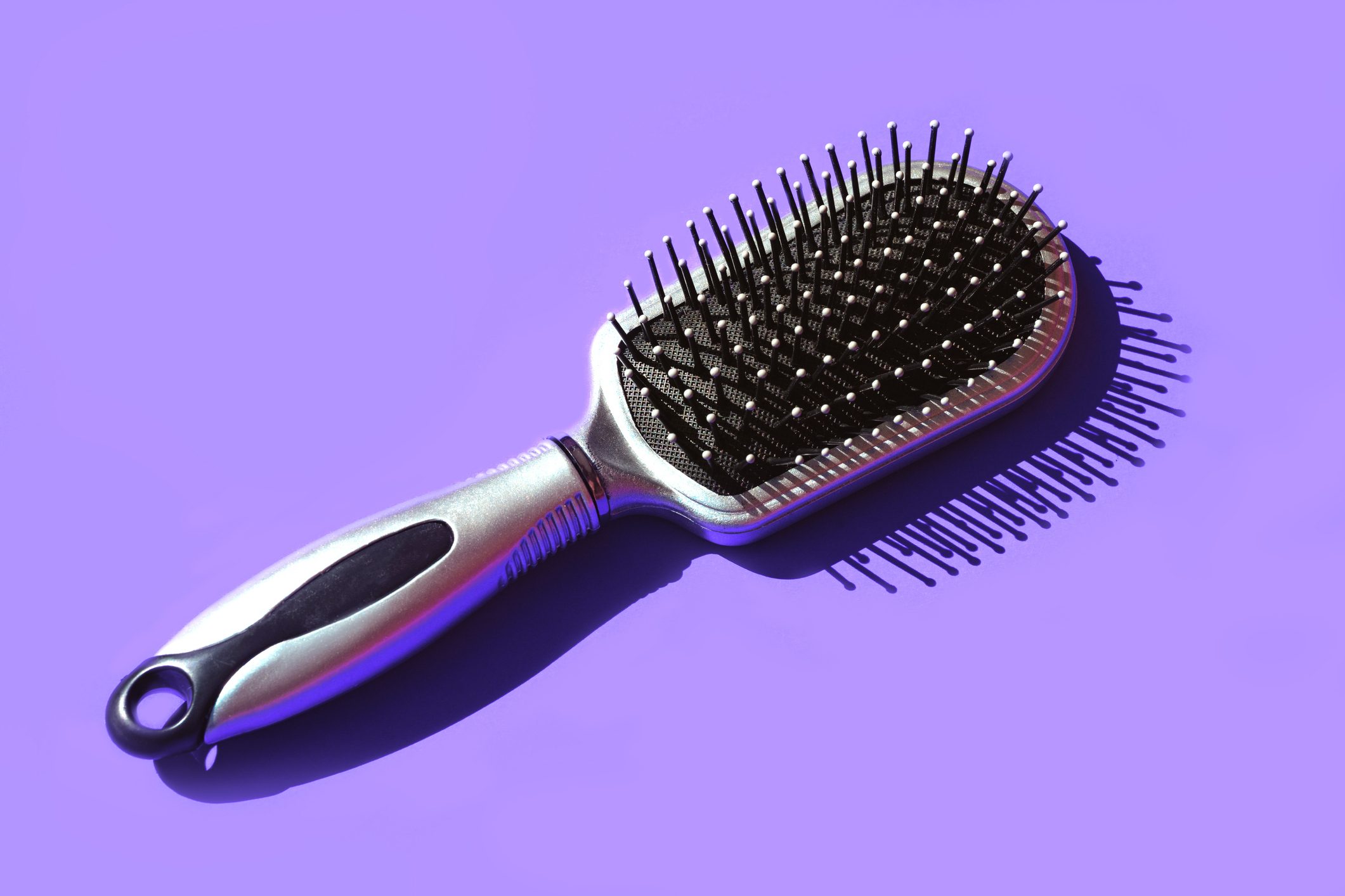 Trendy Beauty Product Pattern made of Hair Brush on pastel lavender violet background.