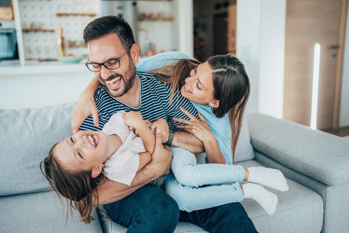 family of three laughing together on april fools day