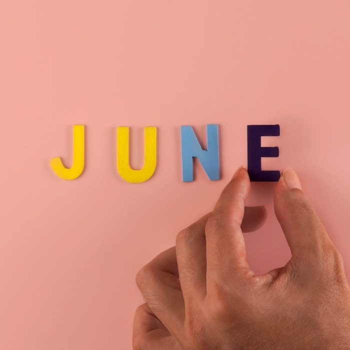 Hand holding , June word block in pink blackground