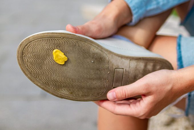 Sticking chewing gum on shoes close-up