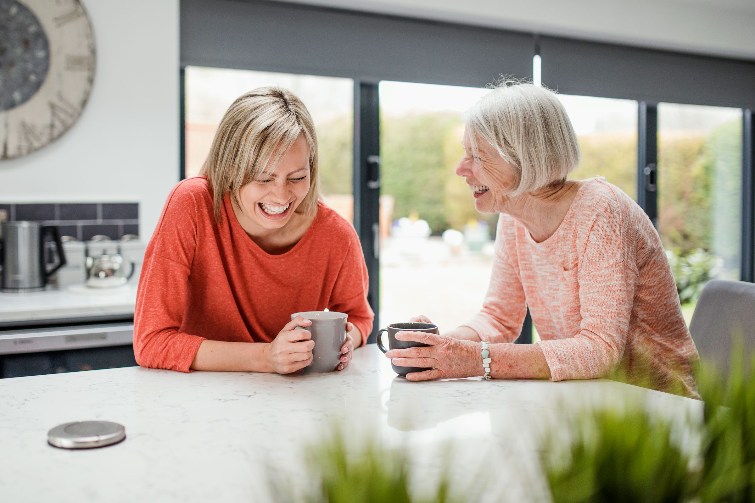mother and daughter laughing in the kitchen