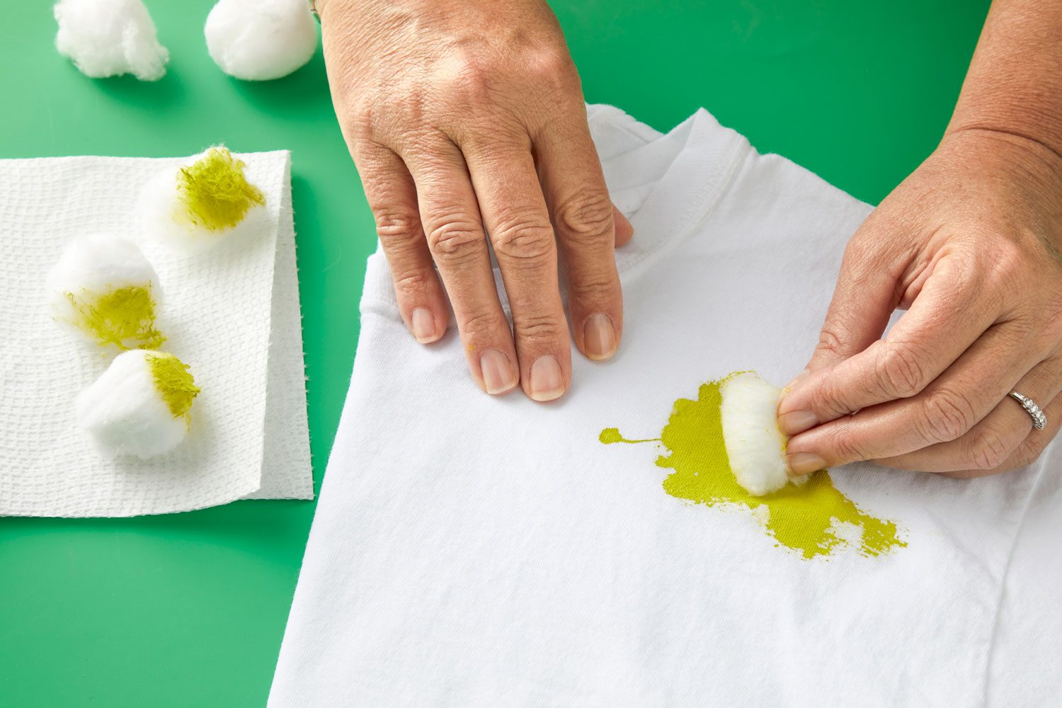 Dabbing oil-based stain with a cotton ball. Other used cotton balls seen nearby