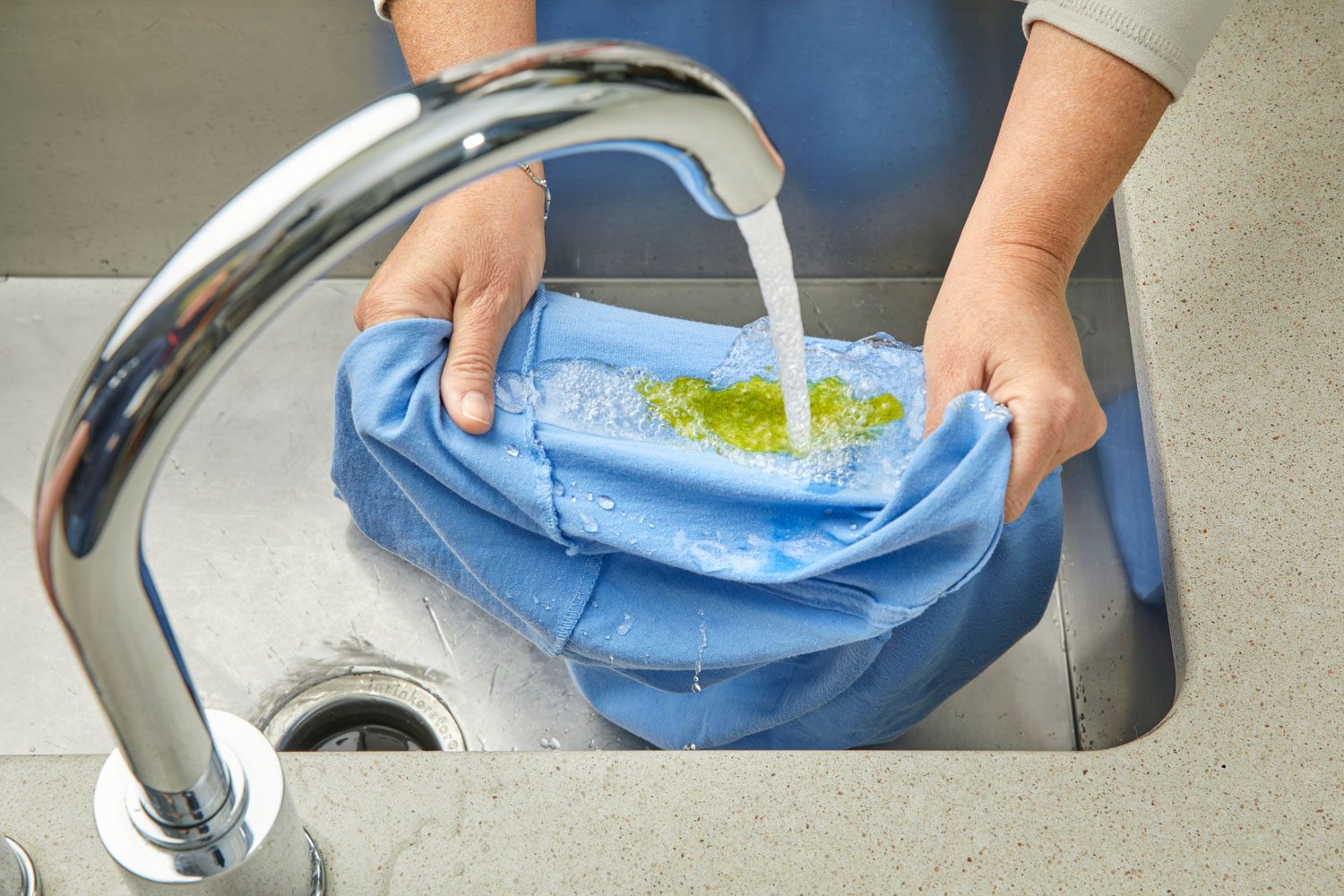 Flushing the stain from behind with water in the sink.