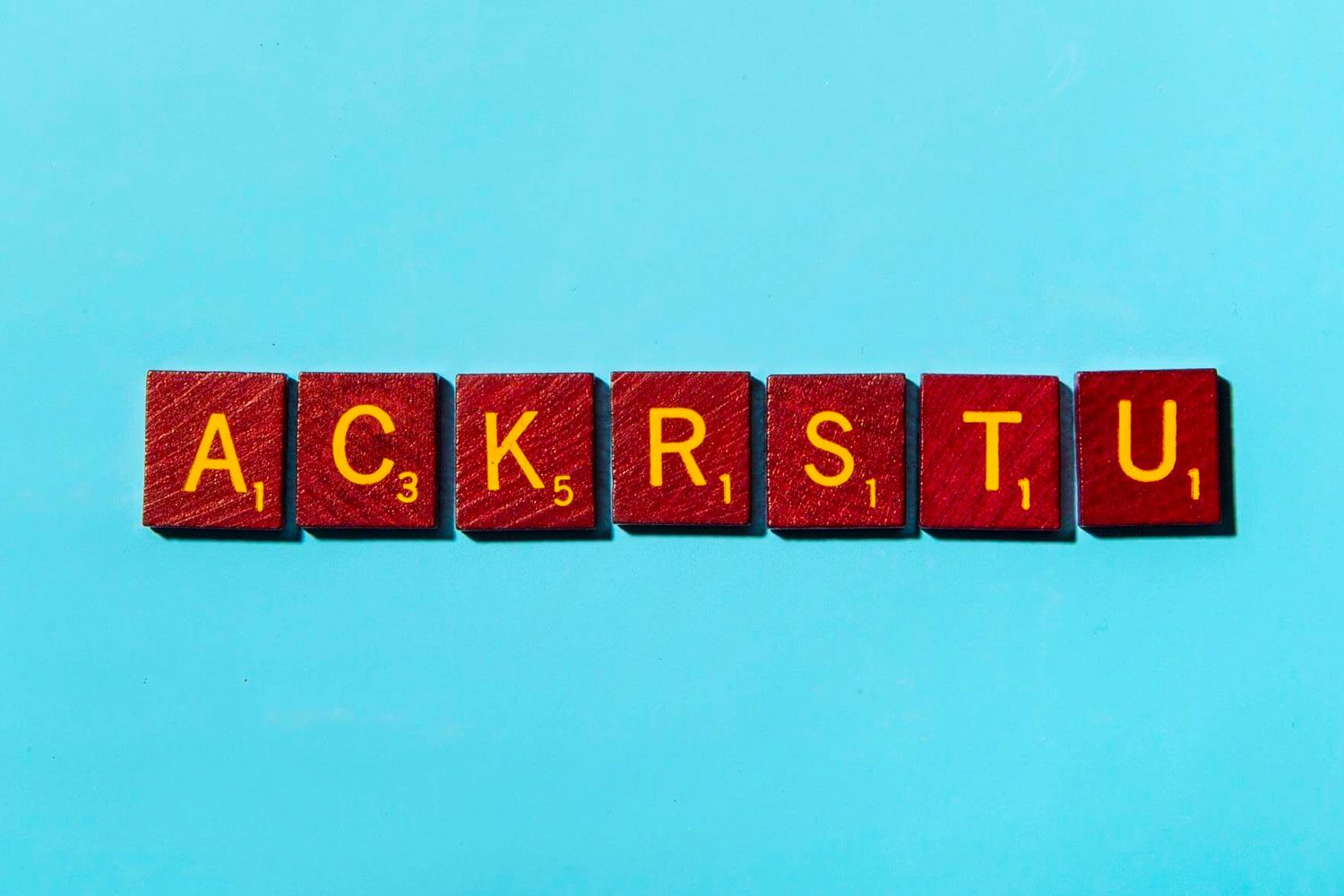 "ACKRSTU" in scrabble letters on a blue background