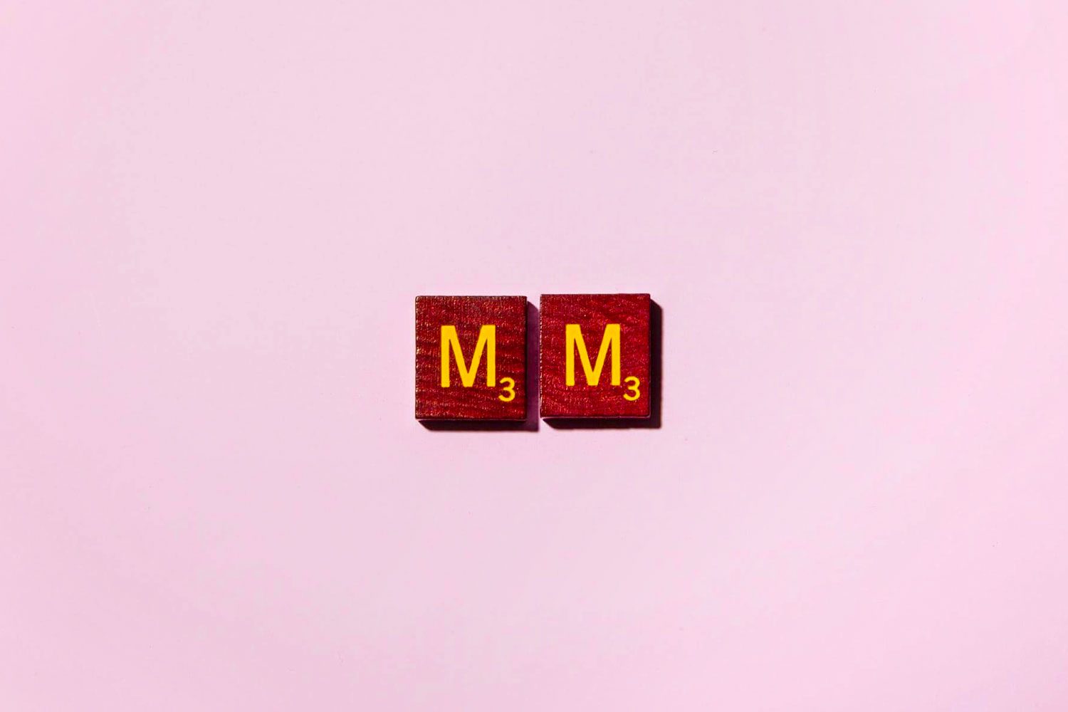 "MM" in scrabble letters on a pink background