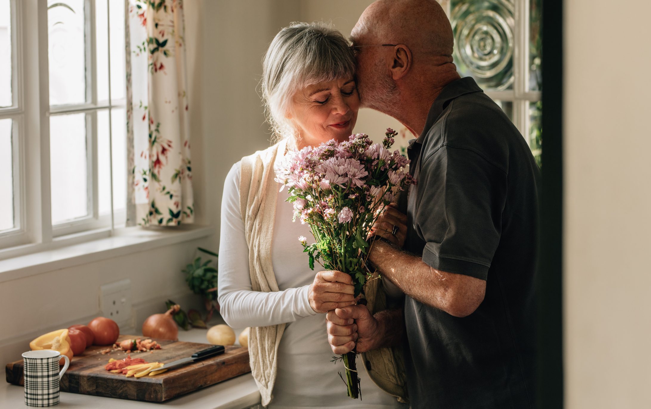 Romantic senior couple at home expressing their love