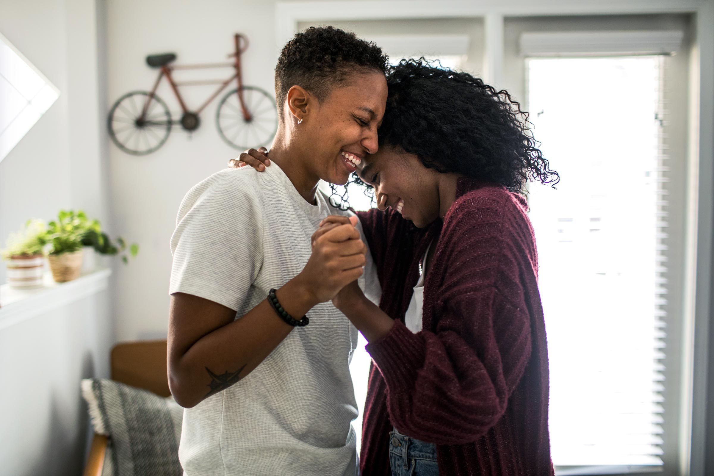 two women lovingly dancing in the house togehter