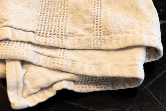 folded white dish towel on kitchen countertop