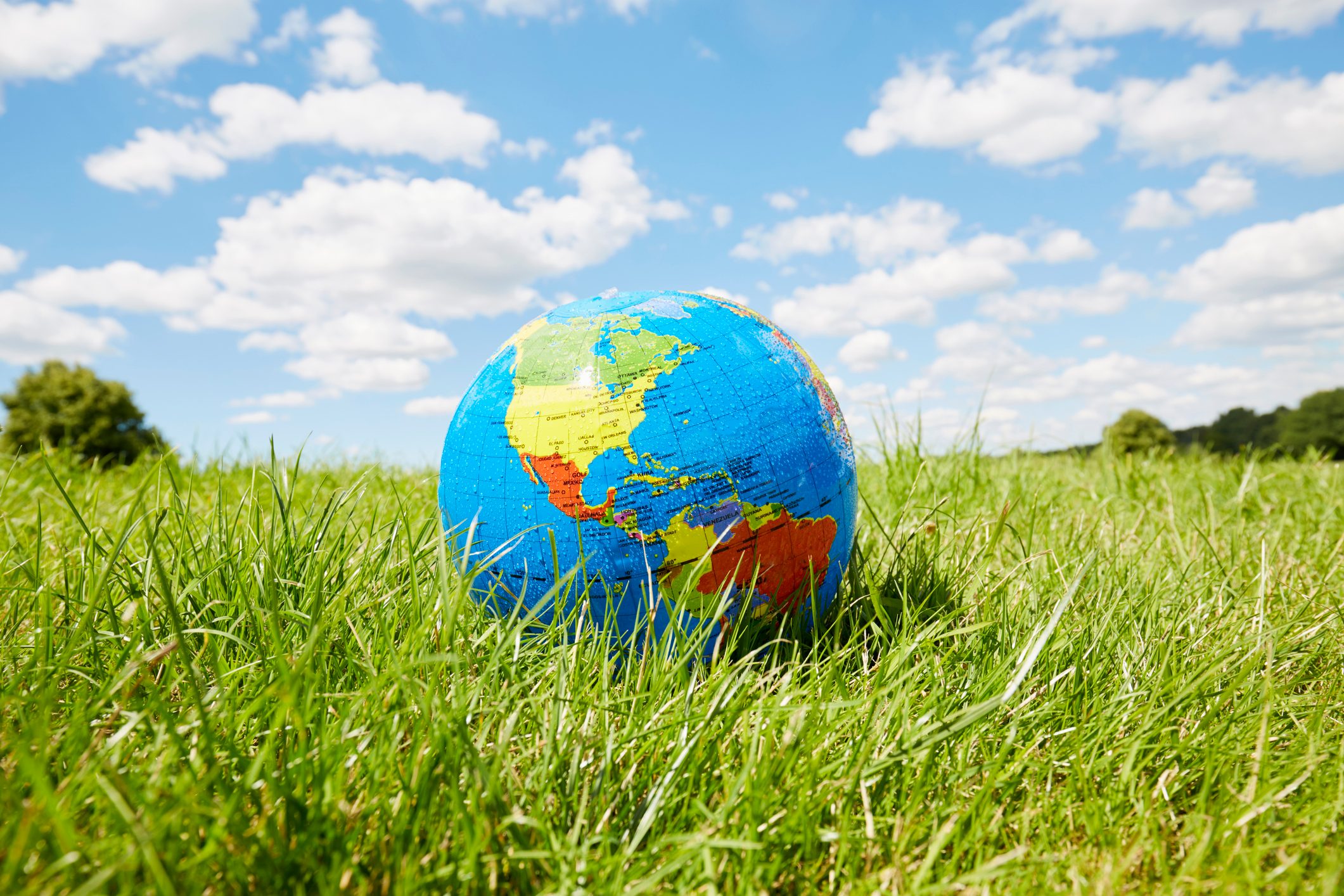 Inflatable globe on a meadow against sky