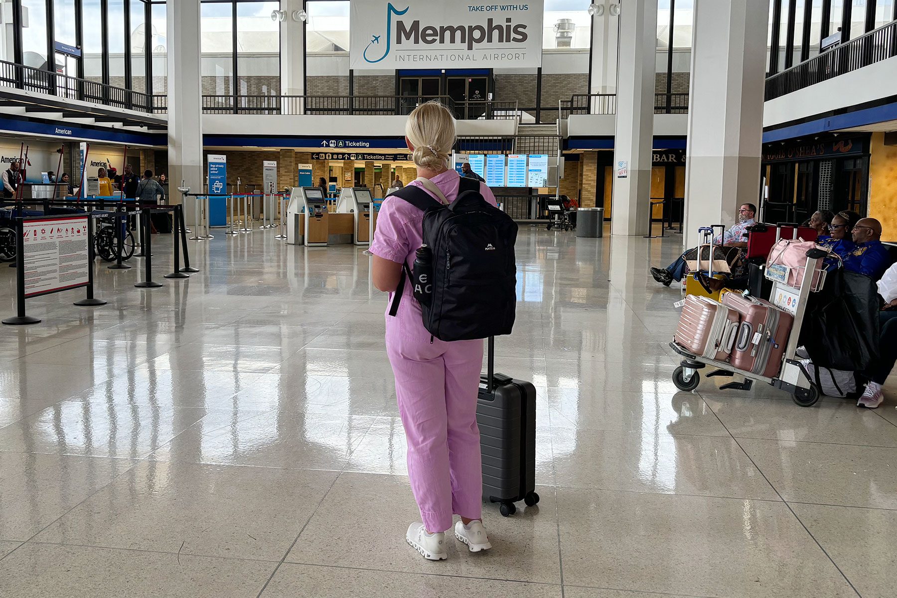 Woman standing with luggage and backpack