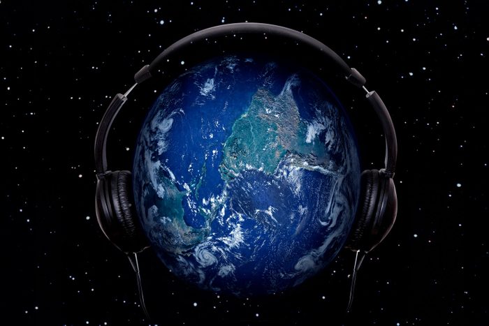 Planet Earth In Headphones on starry sky background