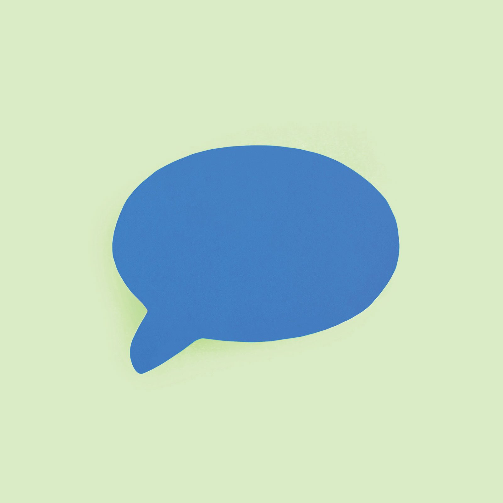 blue paper speech bubble on green background