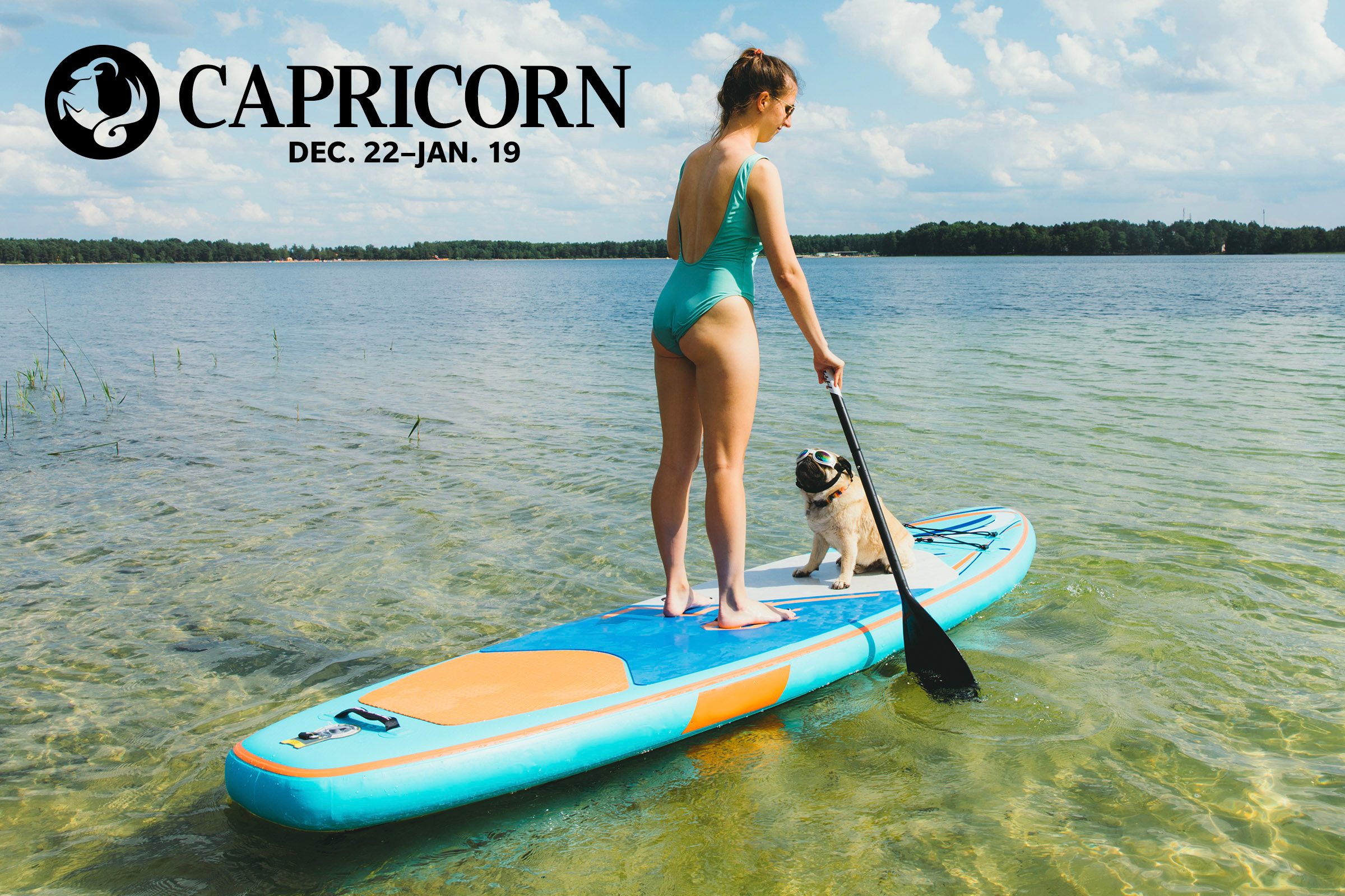 woman and her dog paddle boarding on the lake