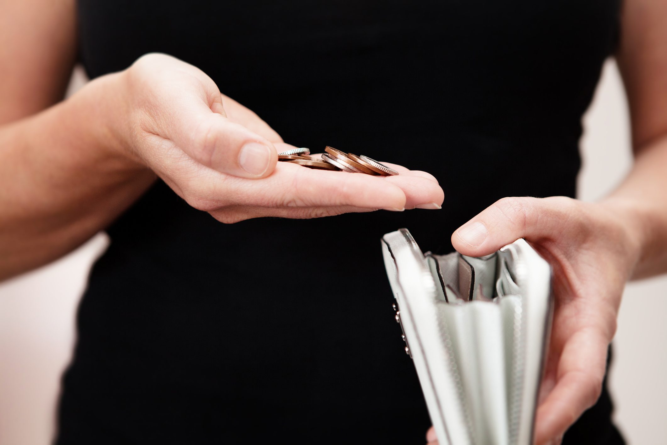 Woman with coins in hand with purse