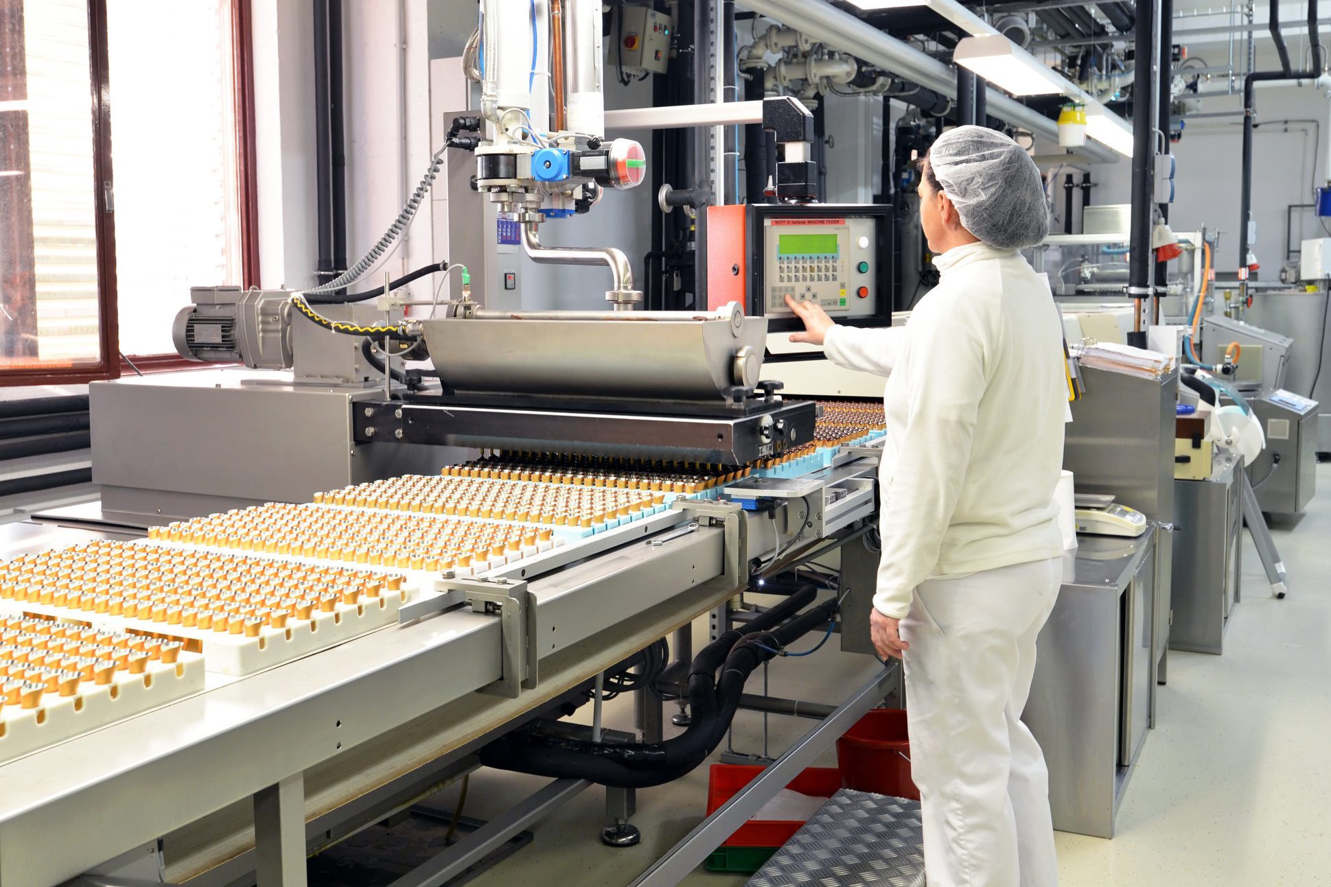 Production of pralines in a factory for the food industry - conveyor belt worker with chocolate