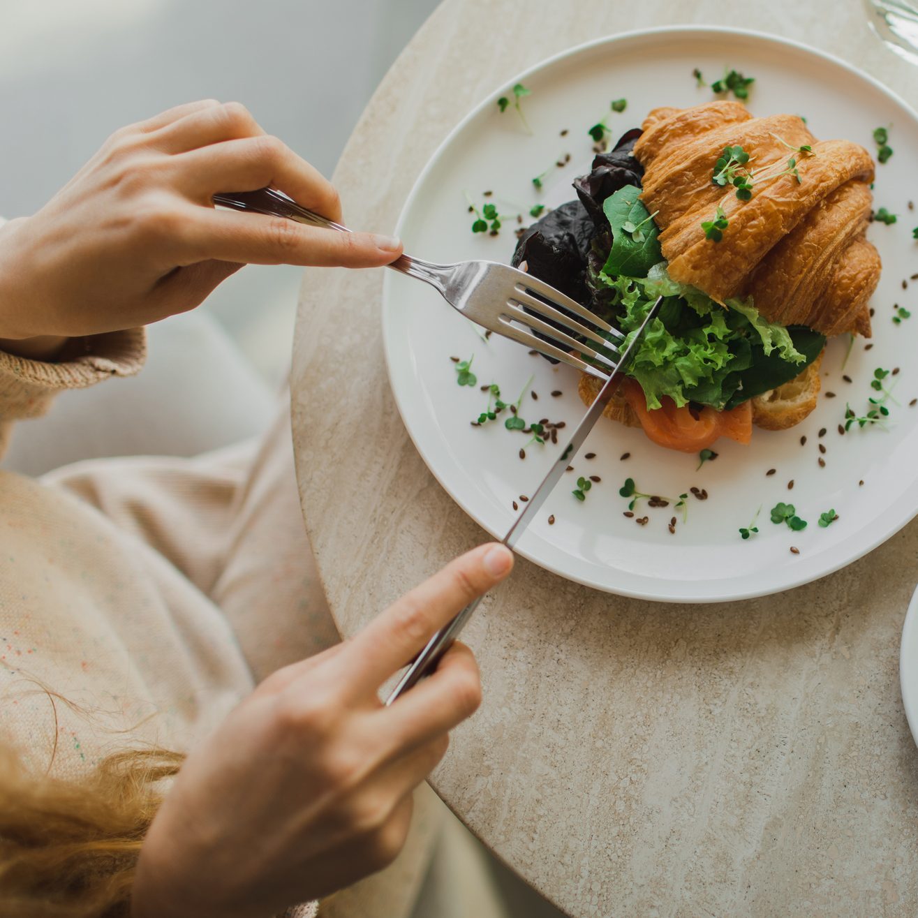 Hands holding fork and knife.