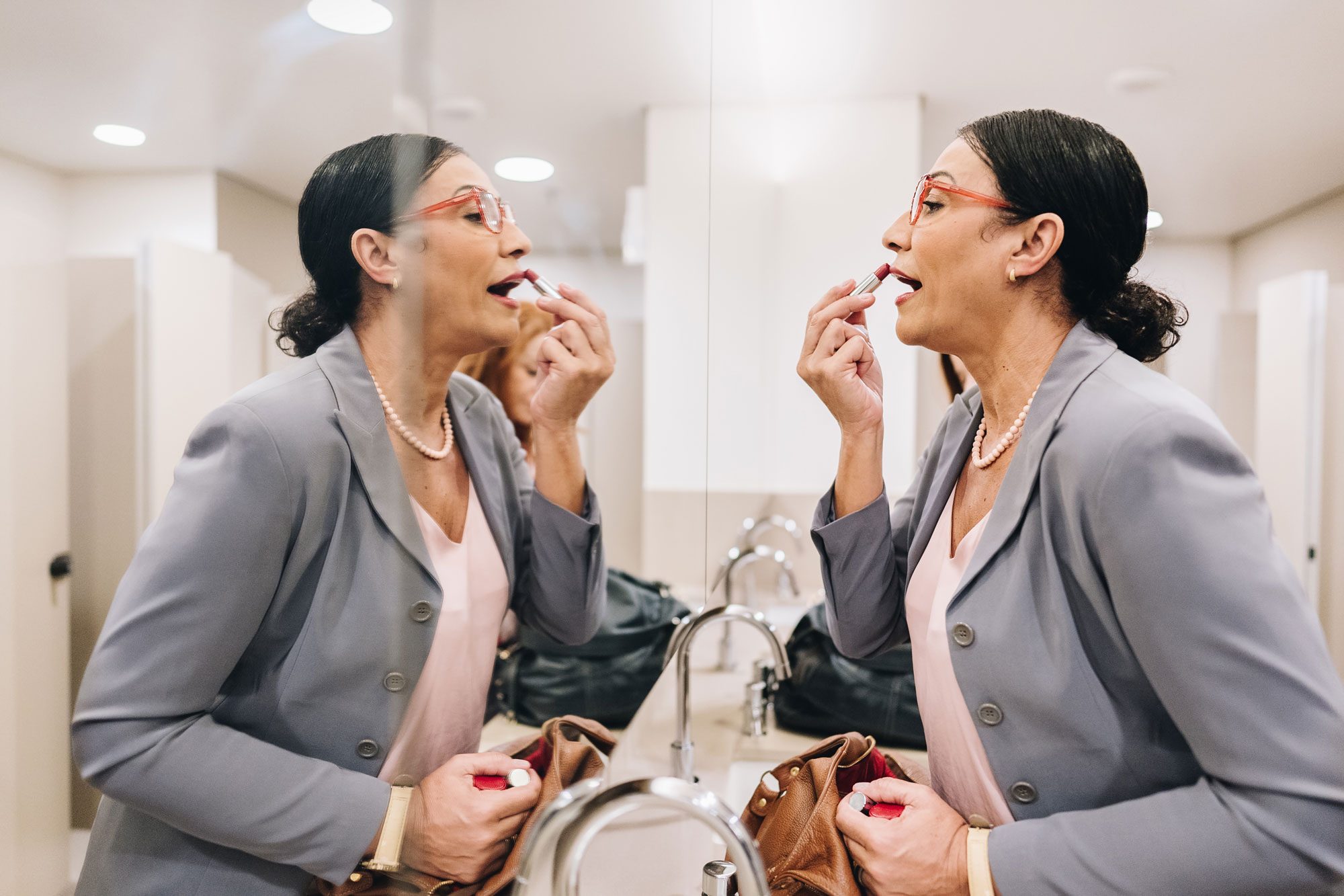 Business Woman Applying Make Up In The Bathroom