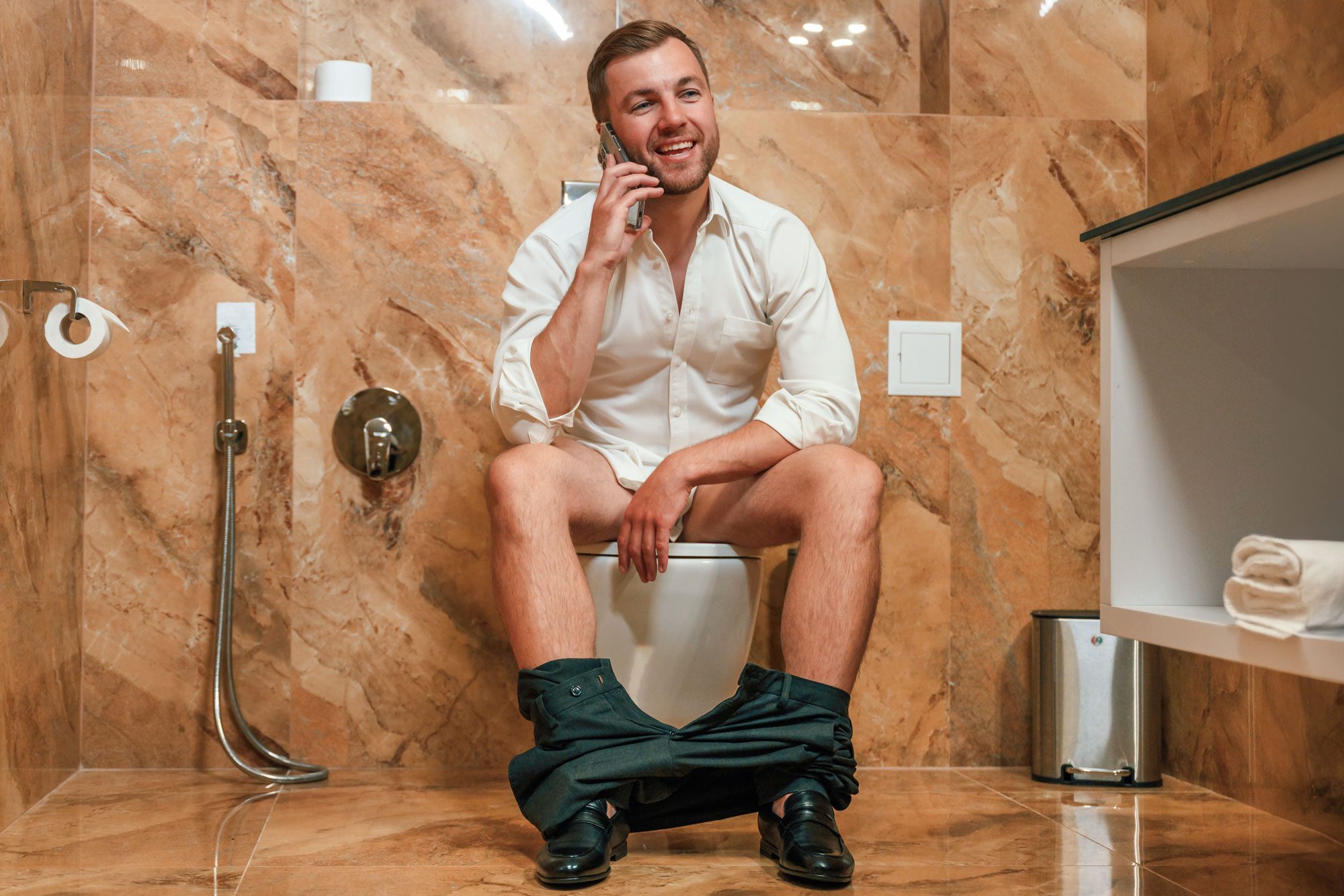 Having A Call A Man In A White Shirt Is Sitting On The Toilet