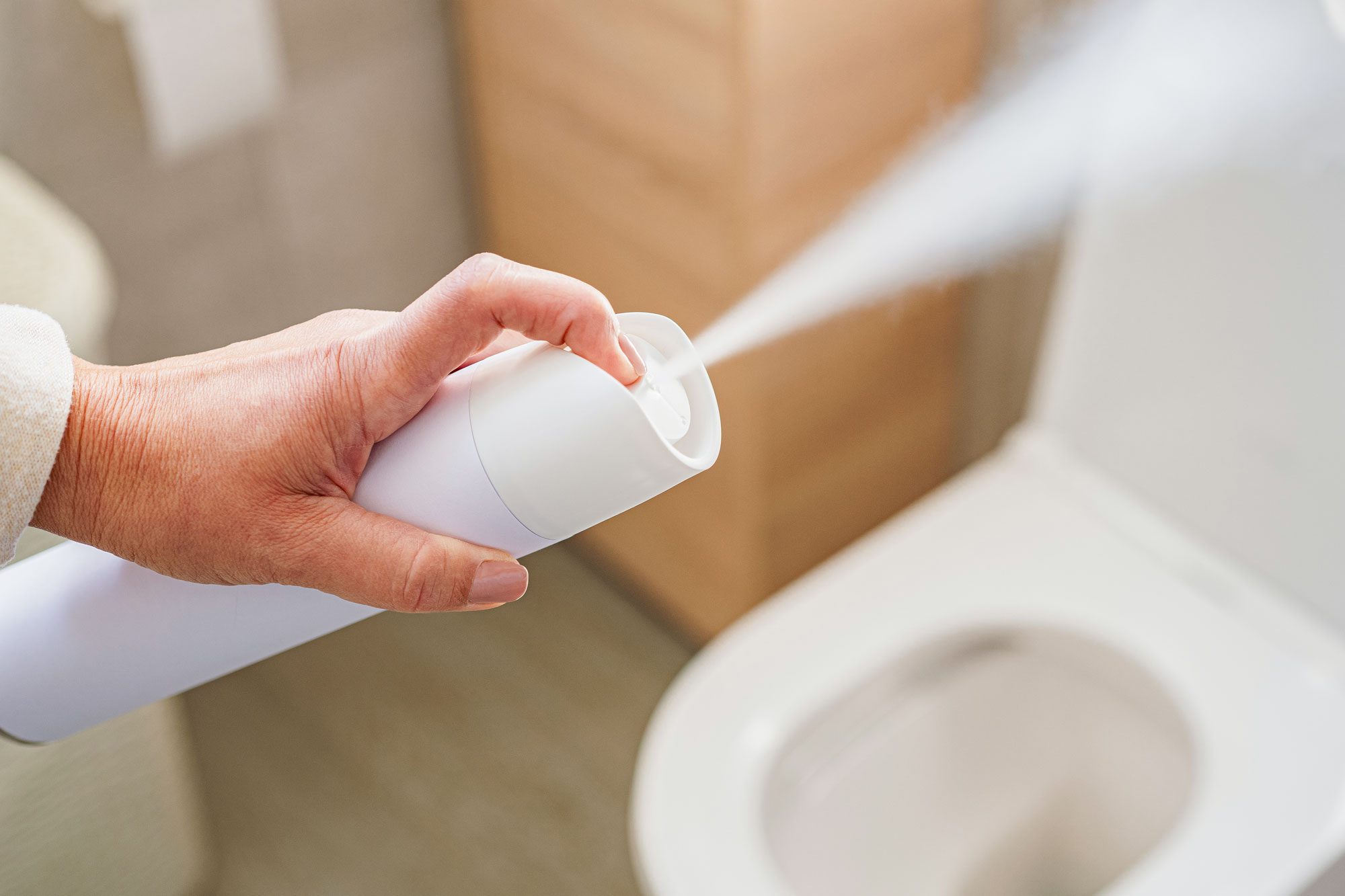 Womans Hand Spraying Air Freshener To Remove Unpleasant Odors Of The Bathroom