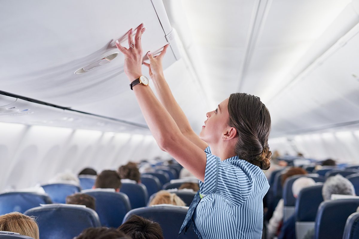 A flight attendant double checks compartments.