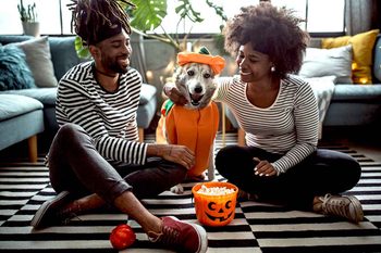 Couple with dog celebrating Halloween.