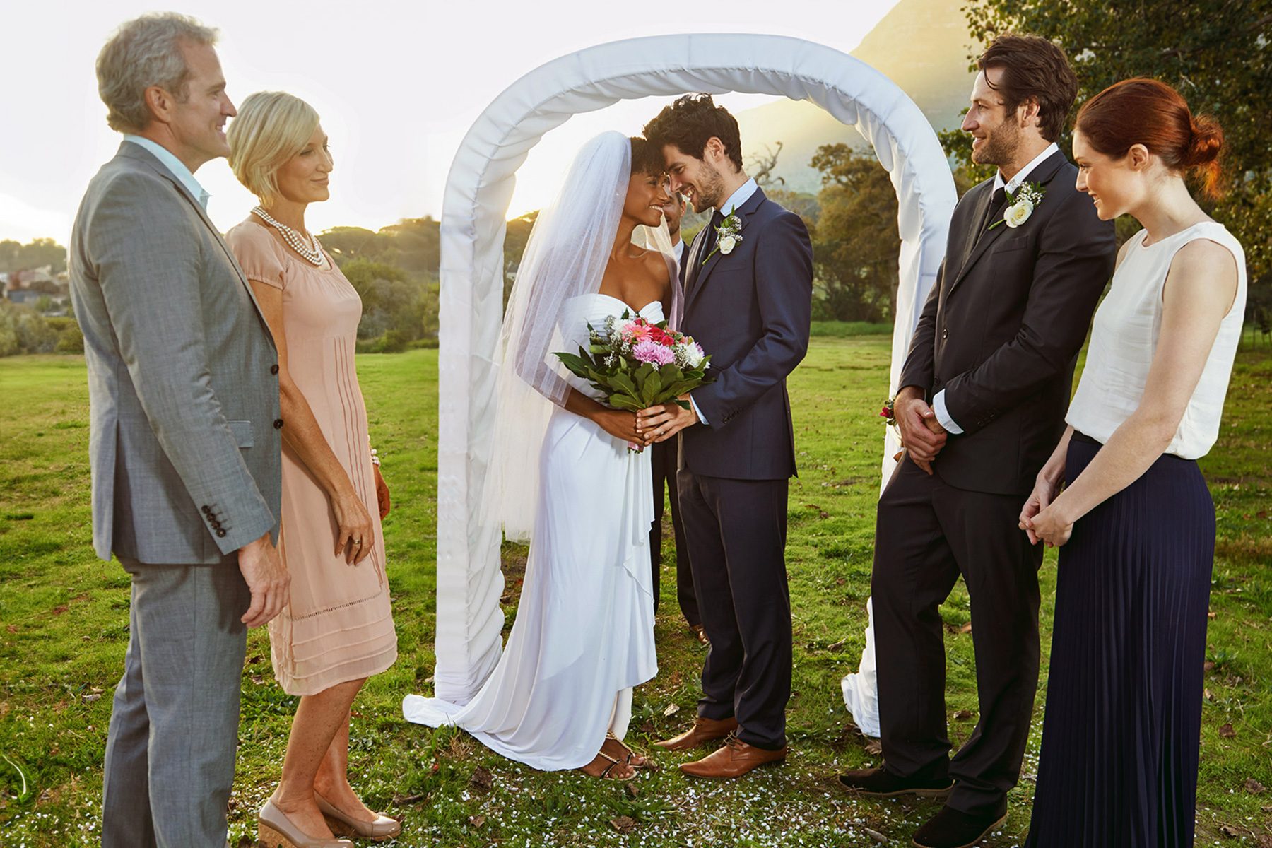 A group of friends watch as the bride and groom say their vowshttp