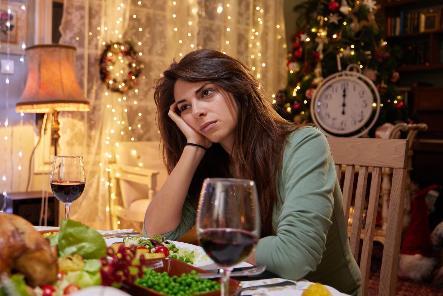 Sad woman alone on New Year's Eve at dining table.