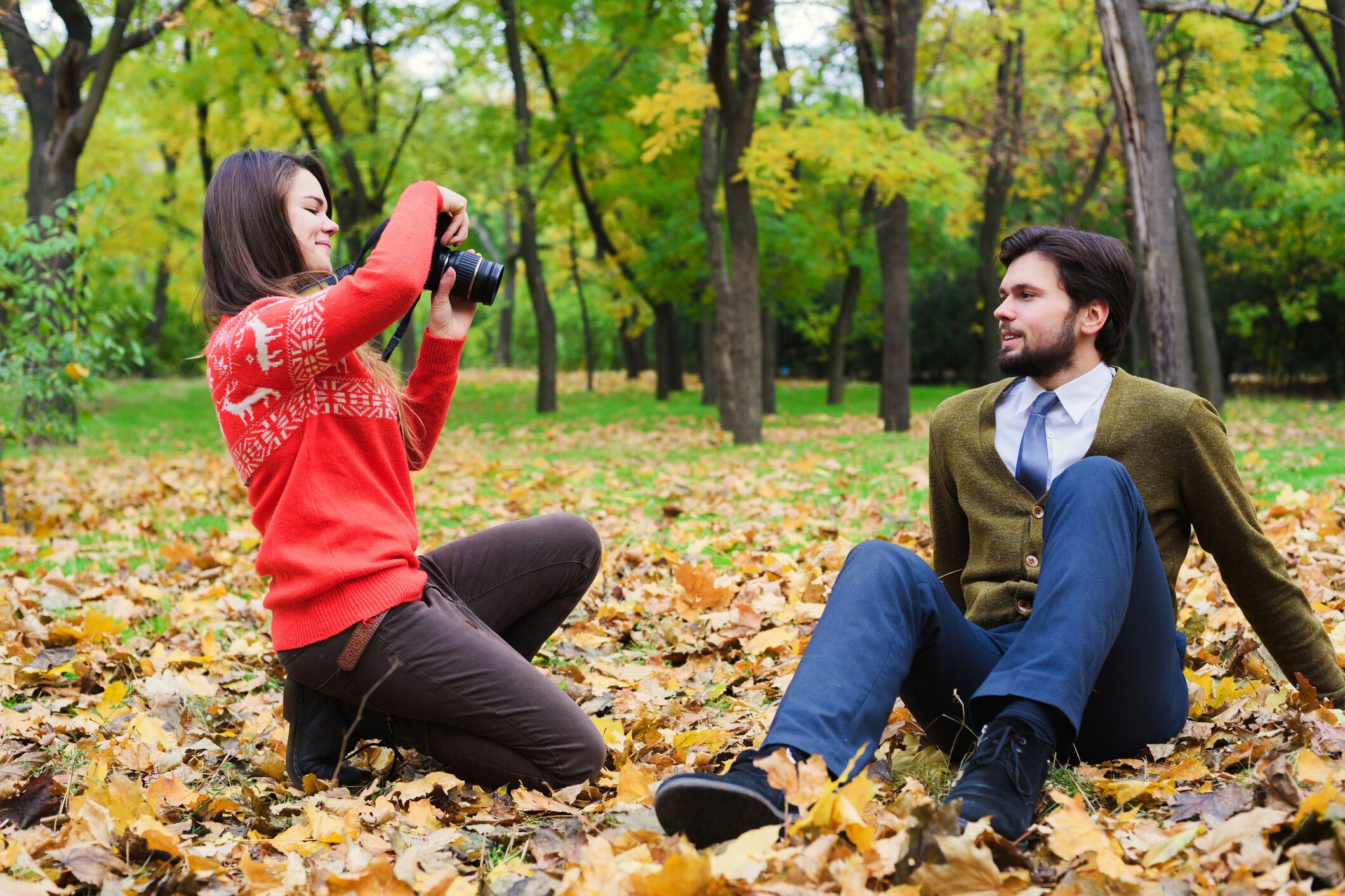 couple taking photos in autumn park
