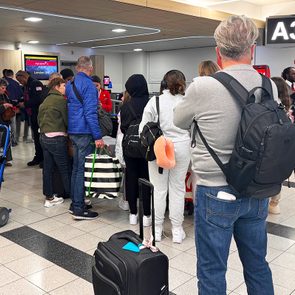 People at the airport congregating around the gate