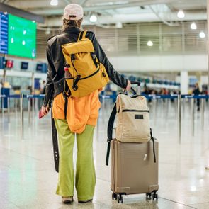 Young Stylish Woman With Bag Pack And Luggage In The Airport