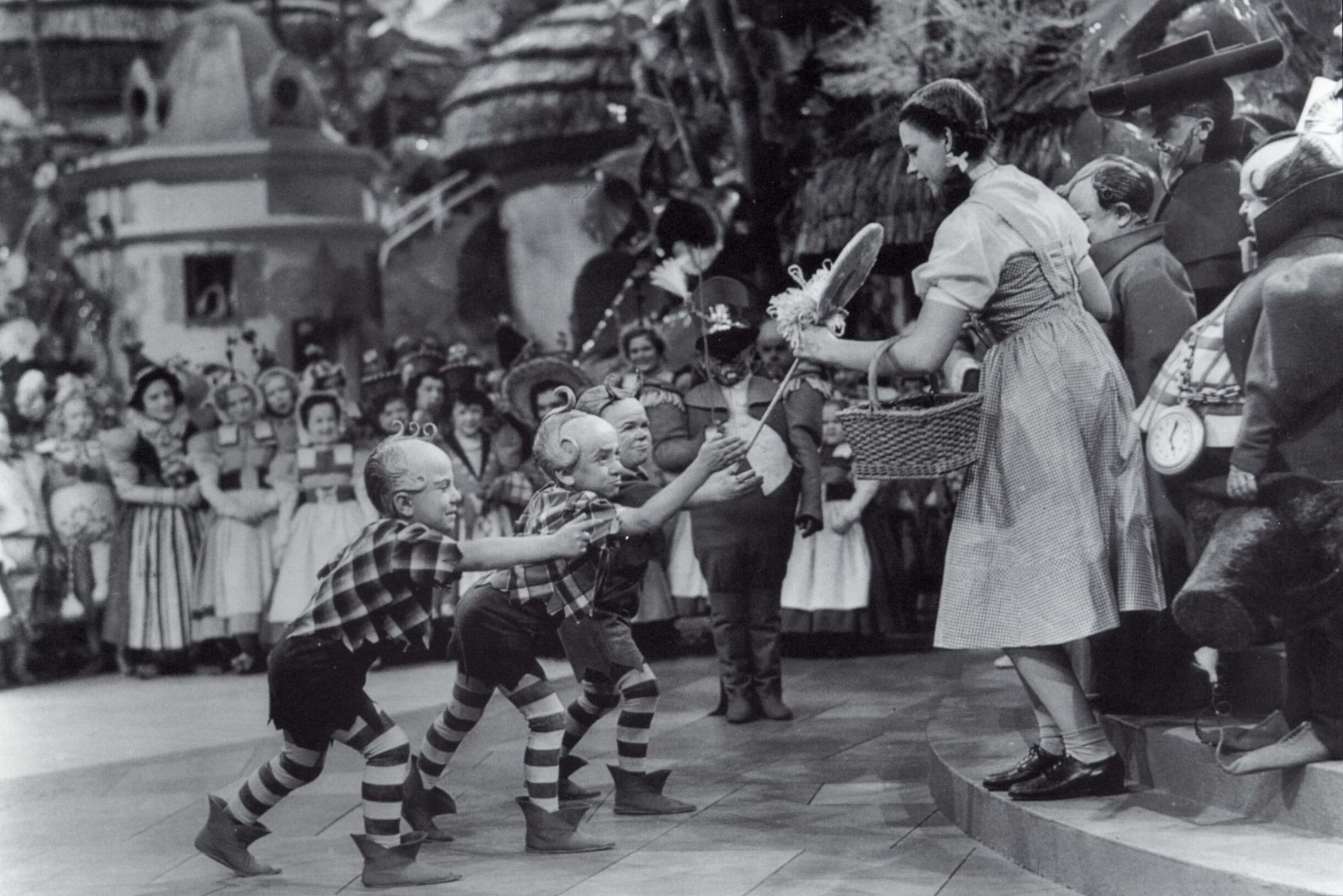Jerry Maren, playing a Lollipop Guild Member, presents Judy Garland with a lollipop in the film "The Wizard of Oz."
