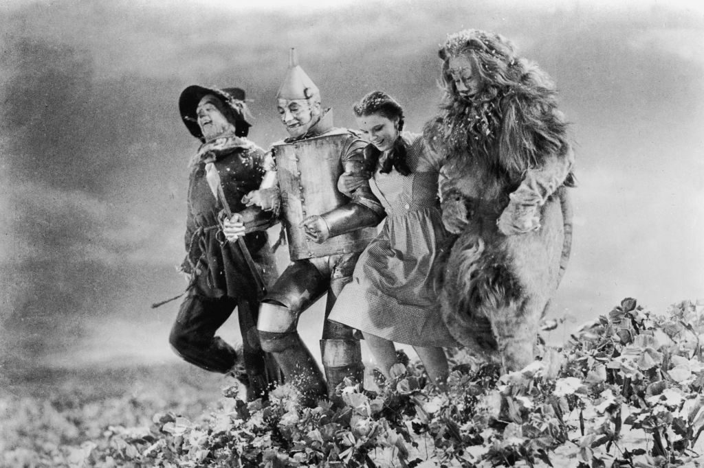 American actors (left - right) Ray Bolger, Jack Haley, Judy Garland , and Bert Lahr run arm in arm through a field of poppies in a still from the film, 'The Wizard of Oz,' directed by Victor Fleming, 1939.