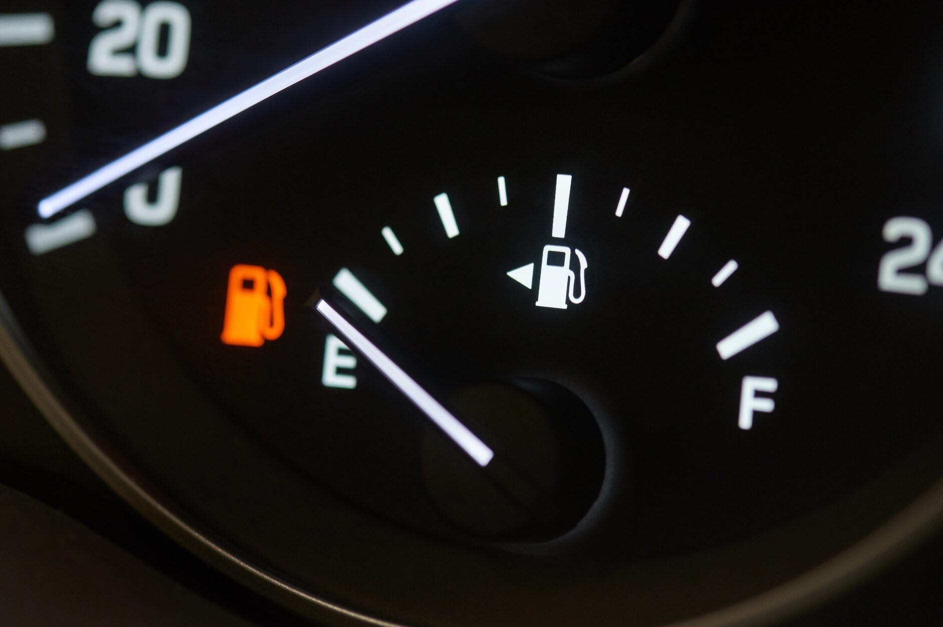 Empty fuel tank indicator close-up on modern car dashboard.
