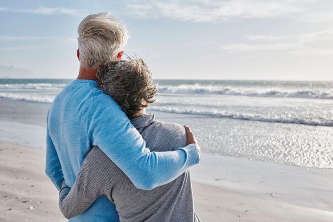 Back view of couple on the beach looking to the sea