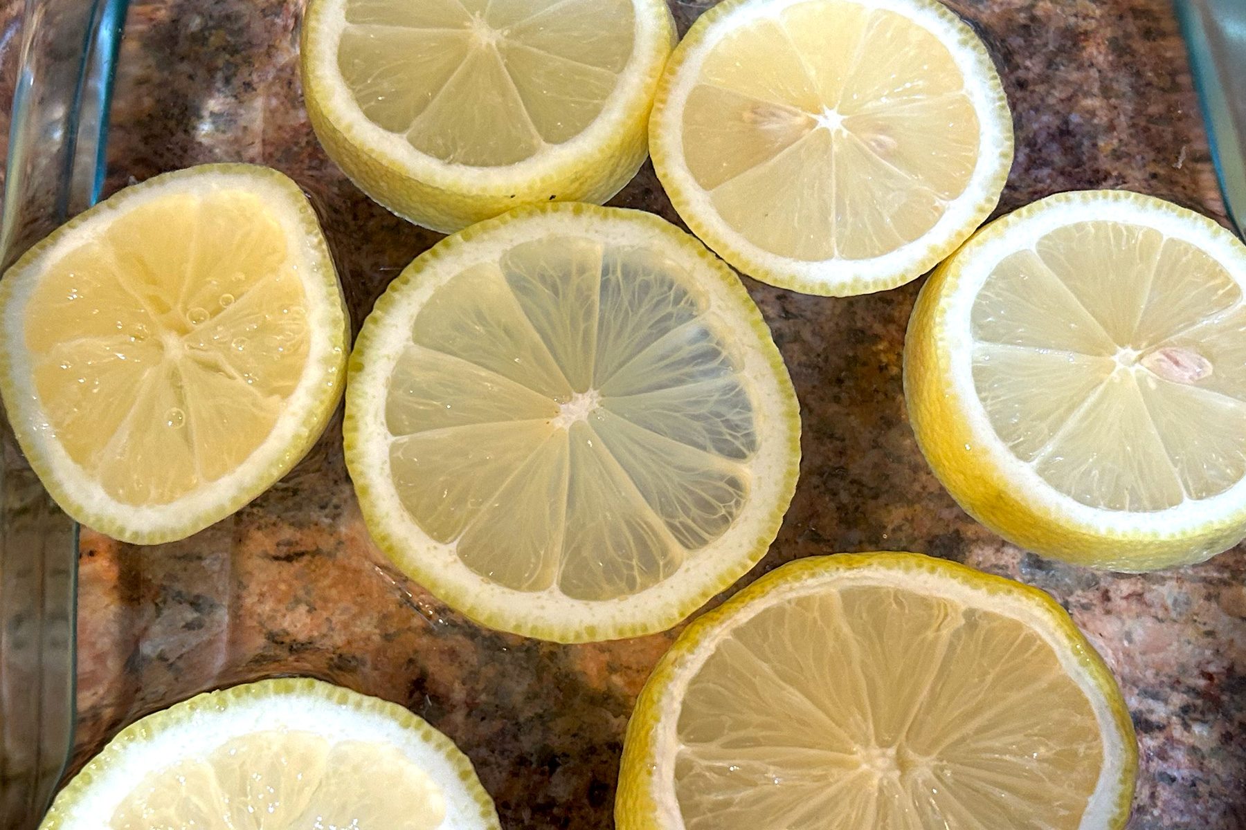 A glass bowl filled with freshly sliced lemons, showcasing their vibrant yellow color and juicy texture