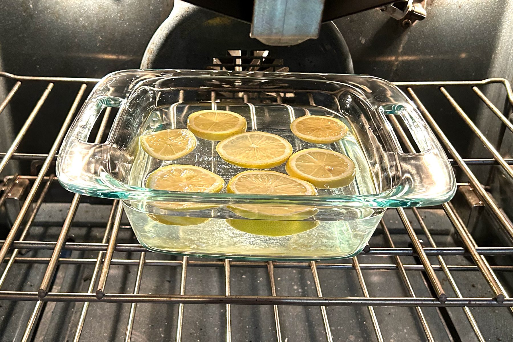 A glass dish filled with fresh lemon slices, showcasing their vibrant yellow color and textured surface