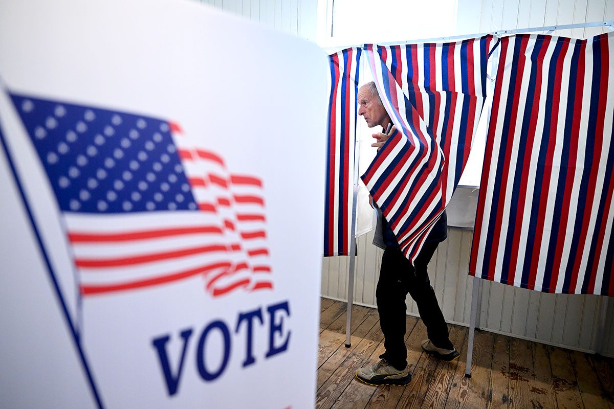 A voter prepares to leave a voting booth as they take part in the New Hampshire primary at Sanbornton Old Town Hall on Tuesday January 23, 2024 in Sanbornton, NH.