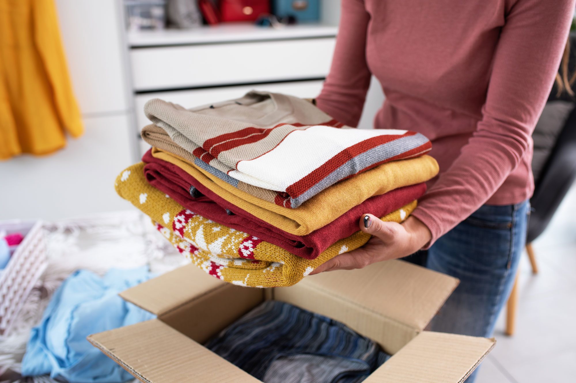 Woman Putting Her Clothes In A Cardboard Box