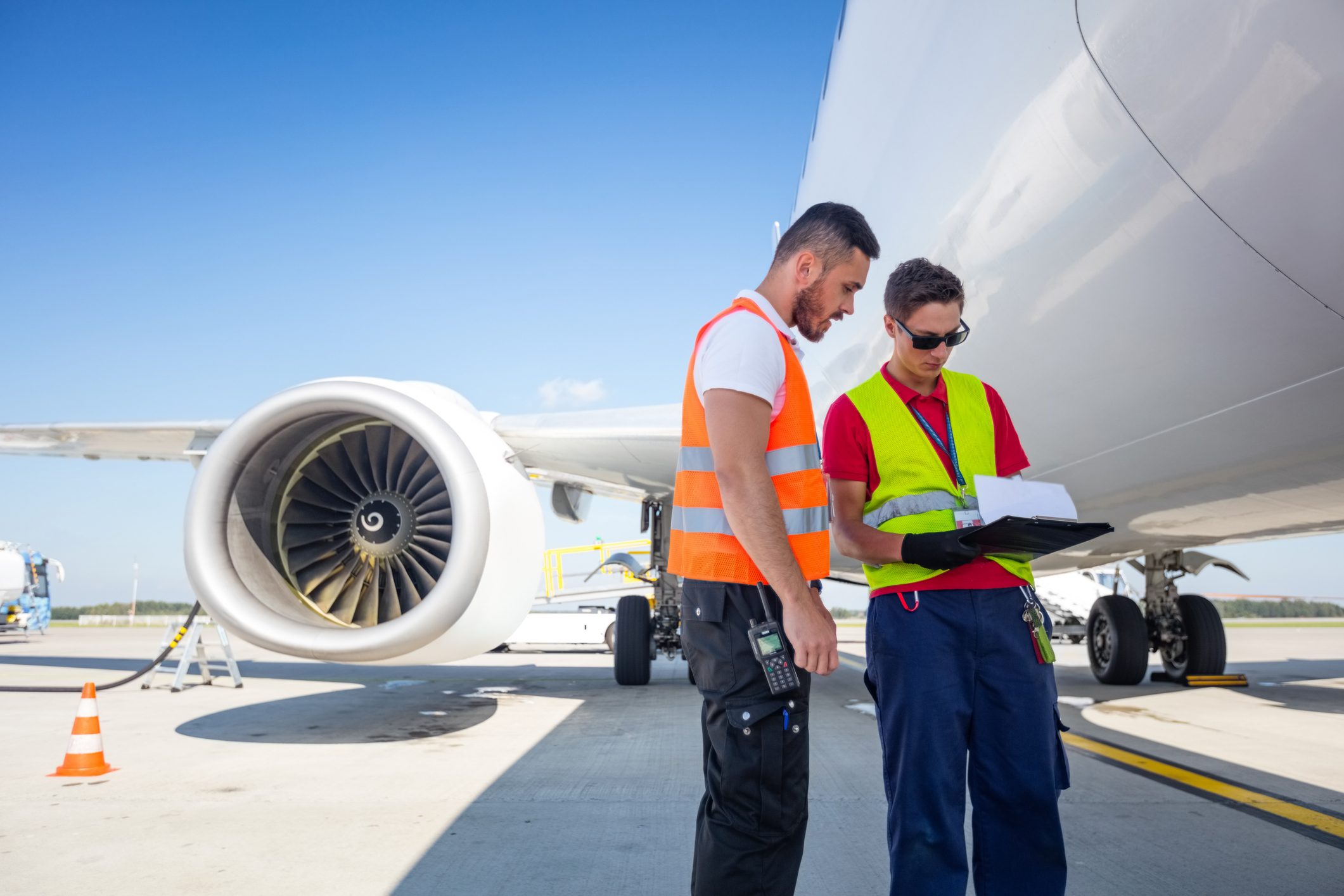 Airport service crew in front of airplane, checking documents