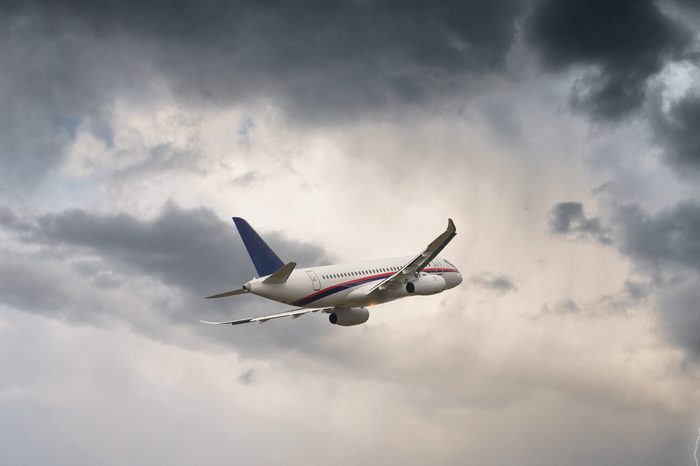 Commercial airplane flying in stormy weather with a lightning - dangerous flight and risk of aircraft accident