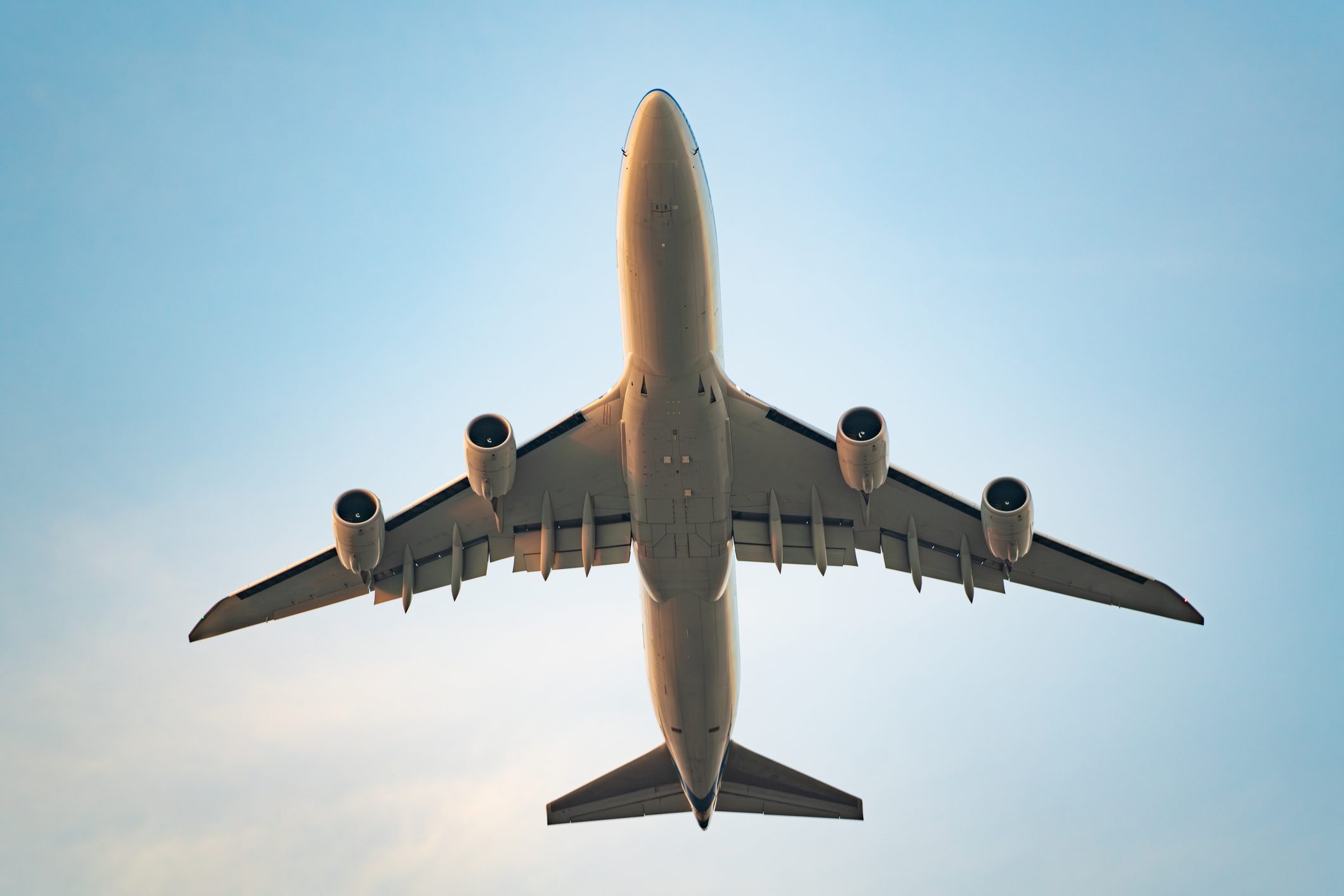 Close-up commercial airplane flying in the sky from the bottom view