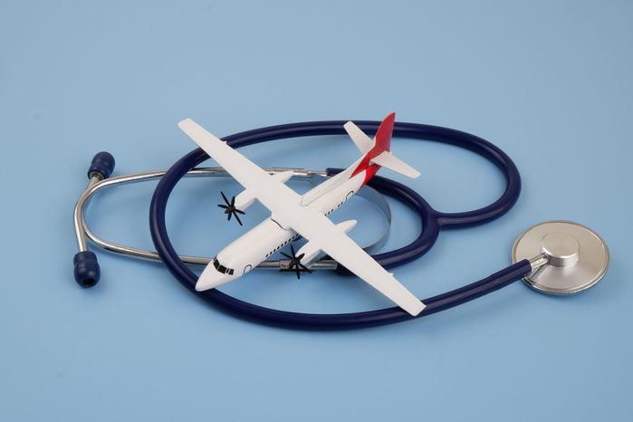 Airplane with blue stethoscope on blue background.