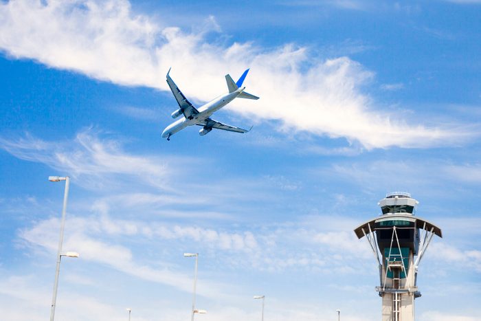Airplane flying and air traffic control tower